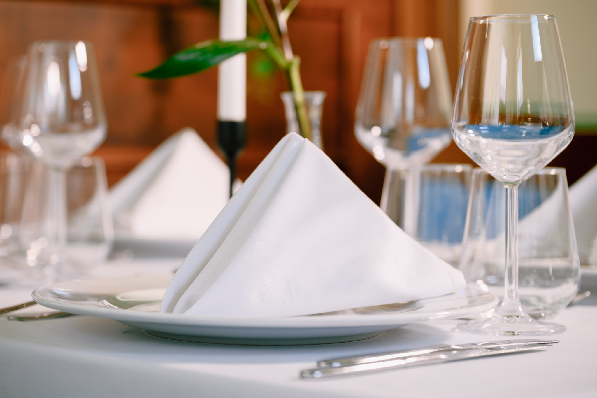 Idee - eveniment perfect Buongiorno 2 - Buongiorno Italian Elegant dining table with a folded white napkin atop a plate and clear glassware in the background.