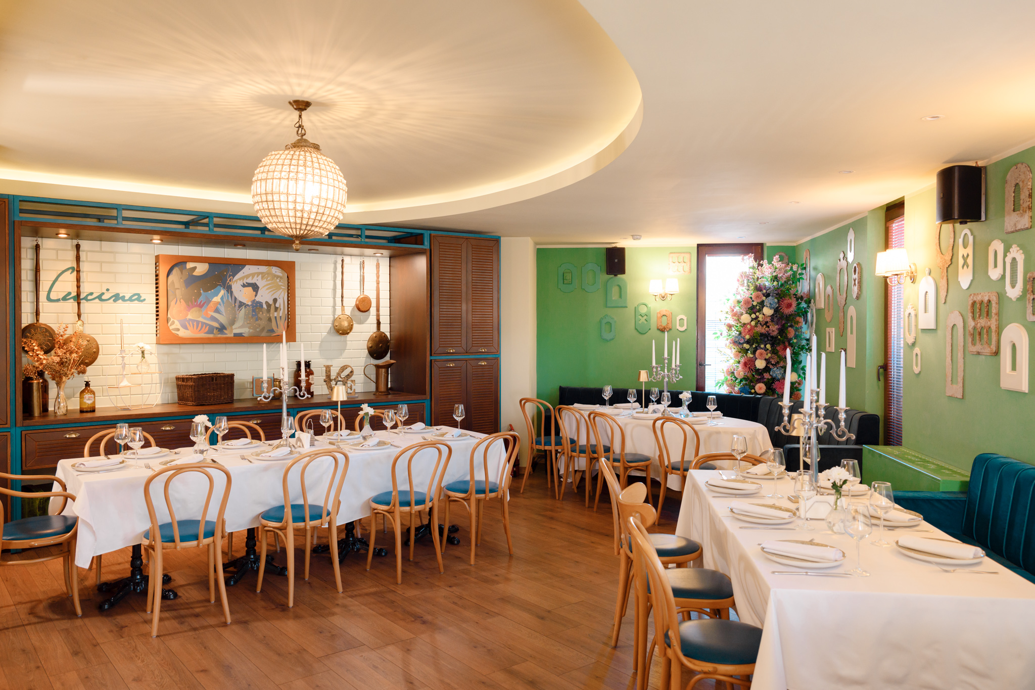 Idee - eveniment perfect Buongiorno 4 - Buongiorno Italian Elegant restaurant dining room with white-clothed tables, wooden chairs, and a large crystal chandelier overhead.